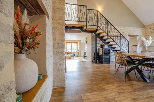 a living room with a table and a staircase at les rives champenoises in Buxeuil