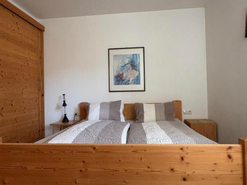 sypialnia z dużym drewnianym łóżkiem z 2 poduszkami w obiekcie Ferienwohnung Eichenspaziert w mieście Hart im Zillertal