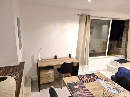 a living room with a desk and a window at rez de villa confort & grand extérieur in Furiani