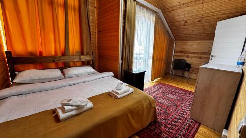a bedroom with a bed with two towels on it at COTTAGE CHALET and TOURS in Dilijan