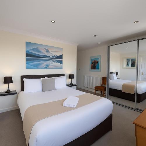 a hotel room with two beds and a desk at Cecil Court Hotel in Bournemouth