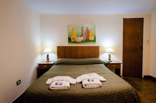 een slaapkamer met een bed met twee handdoeken erop bij Carlos Paz Departamentos in Villa Carlos Paz