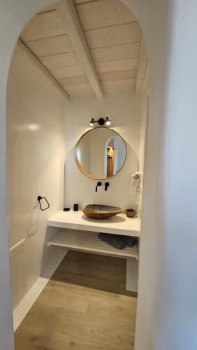 ein Badezimmer mit Waschbecken und Spiegel in der Unterkunft Aether Mykonos 3BR Villa with Serene Port & Town Views in Tourlos