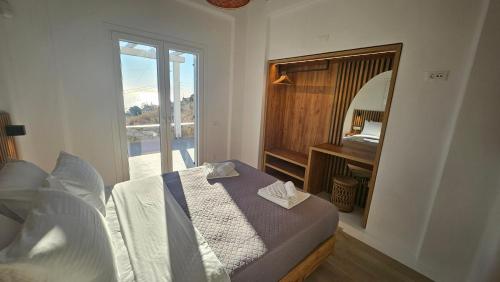 ein Schlafzimmer mit einem Bett und einem großen Spiegel in der Unterkunft Aether Mykonos 3BR Villa with Serene Port & Town Views in Tourlos