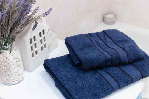 two towels on a bathroom counter with a vase of flowers at Standard 1-bd Apartment LAVINA in Sumy