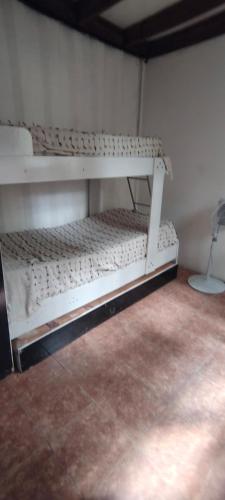 un letto a castello bianco, posto in una stanza di Guazubira a Guazuvirá