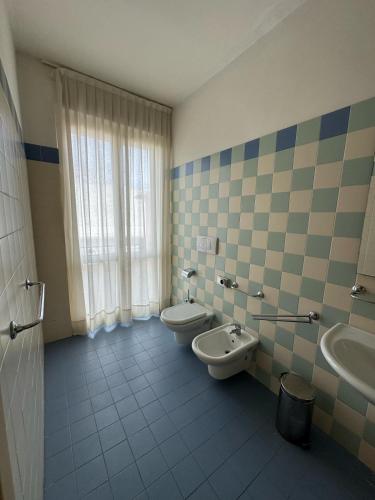 a bathroom with two toilets and two sinks and a window at Hotelleria di Ovada in Ovada