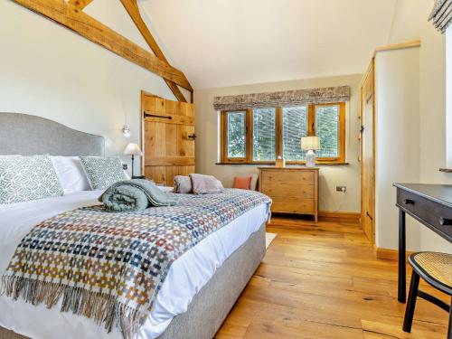a bedroom with a bed and a desk and windows at 1 Bed in Leominster 95609 in Pencombe