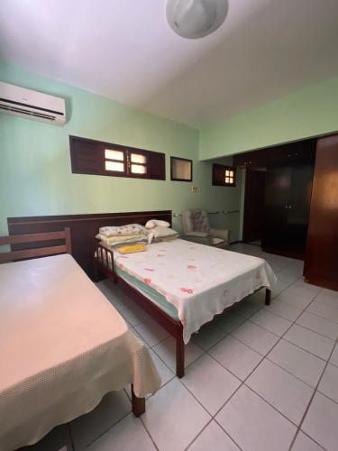 纳塔尔Casa em Cidade Verde - Nova Parnamirim的有两张床和一把椅子的卧室