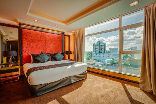 una camera da letto con un letto grande e una grande finestra di Fields Plaza Hotel by ABC a Angeles