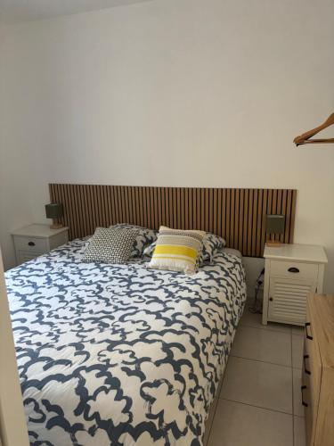 卡里勒鲁埃Joli Appartement proche du port de carry le rouet的卧室里有一张床，床铺有蓝白相间的被子