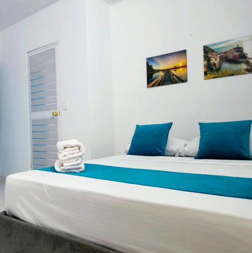 a bed with blue and white sheets and towels on it at Hospedaje Torices Cartagena in Cartagena de Indias