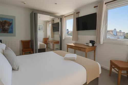 a hotel room with a bed and a television at Cecil Court Hotel in Bournemouth