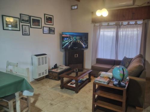Una sala de estar con un sofá y un televisor de pantalla plana. en Casa Casuarina, en General Belgrano
