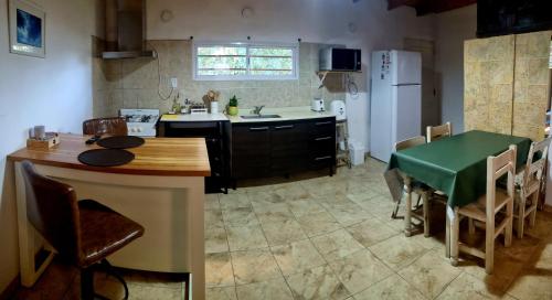 cocina con mesa verde y nevera en Casa Casuarina, en General Belgrano