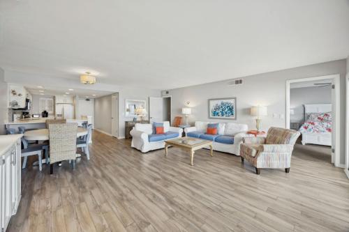 a living room with a couch and a table at Beach Cottage Look Condo, Ocean View from Spacious Balcony in Fernandina Beach