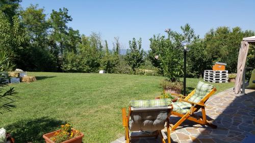 a patio with a chair and a grass yard at Country House Bucaneve in Rovolon