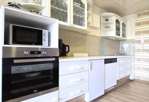 eine Küche mit weißen Schränken und einer Mikrowelle in der Unterkunft Ferienwohnung Möwe in Schönberg