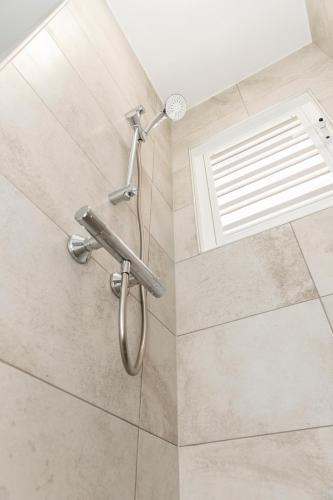 a shower in a bathroom with a shower head at Kasa Blou in Kralendijk