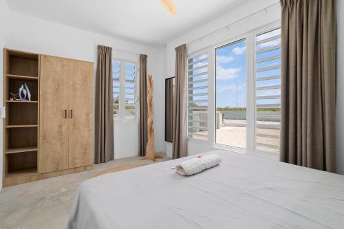 a bedroom with a bed with a view of the beach at Kasa Blou in Kralendijk