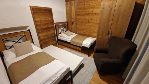 Un dormitorio con una cama y una silla en una habitación. en Apartment ABAKUS with jacuzzi & sauna, en Demänovská Dolina