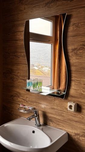 a bathroom with a sink and a mirror and a window at COTTAGE CHALET and TOURS in Dilijan