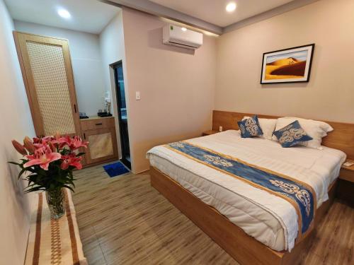 a bedroom with a bed and a vase of flowers at Villa Phước Nguyên in Ấp Bình Hưng