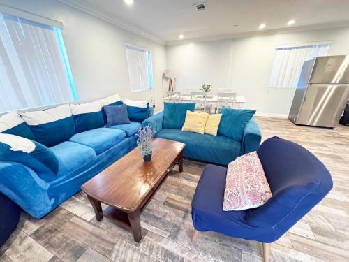 a living room with blue couches and a table at 5 BR Home Near USC - Perfect Location in Los Angeles