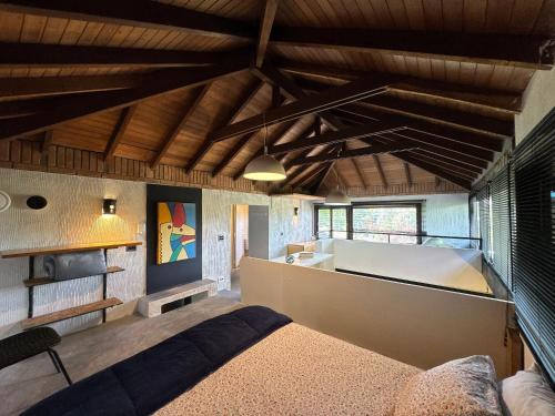 a bedroom with a bed in a room with wooden ceilings at Loft Aconchegante com Atmosfera Intimista em Meio à Natureza – Granja Viana in Carapicuíba
