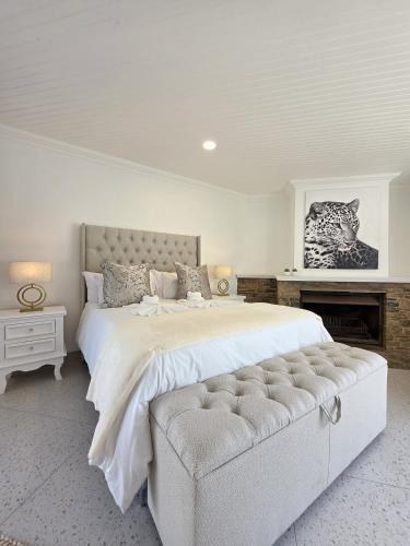 White Cottage Boutique Guesthouse في سواكوبموند: غرفة نوم بها سرير كبير وأريكة