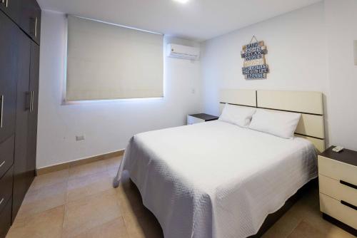 una camera da letto con un letto bianco e una finestra di Suite apartment 201 Playa Santa Marianita Manta by BRISAMAR a Manta