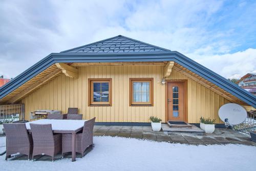 巴德米滕多夫Ferienwohnung Grimmingblick的雪地里带桌椅的房子