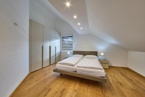 巴德米滕多夫Ferienwohnung Grimmingblick的一间白色的大卧室,配有床和木地板