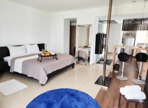 a bedroom with a bed with a table and a television at Palma Real Beach Club in Playa Blanca