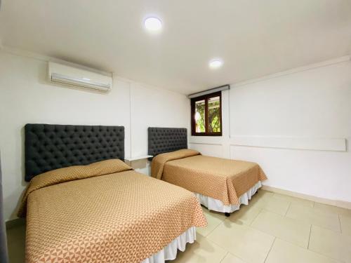 a room with two beds and a window at Casa San Juan 560 in Managua