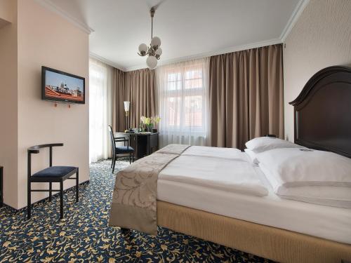 Una habitación de hotel con una cama grande y un escritorio. en Hotel Esprit, en Praga