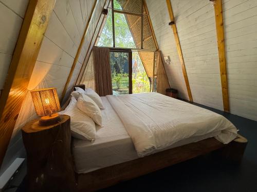 a bed in a room with a large window at Luma in Palolem