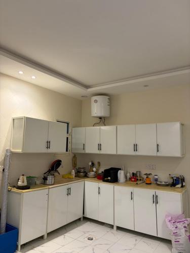 eine Küche mit weißen Schränken in einem Zimmer in der Unterkunft Friendly apartment with friendly pet in Riad