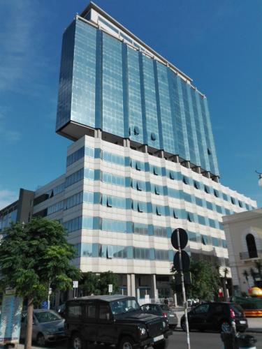 un grande edificio in vetro con macchine parcheggiate di fronte di Sul Tetto di Gallipoli a Gallipoli