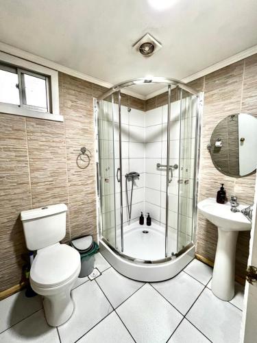 a bathroom with a shower and a toilet and a sink at Hostal Las Heras in Temuco