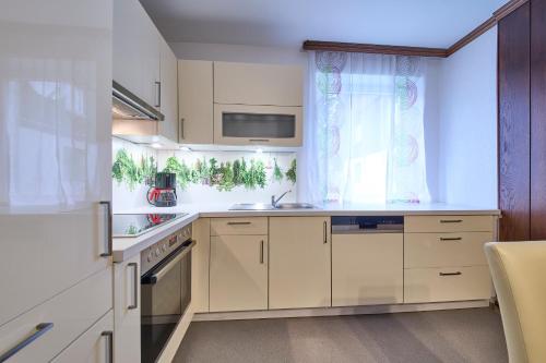 Una cocina con gabinetes blancos y una ventana. en Ferienwohnung Brigitte, en Bad Mitterndorf
