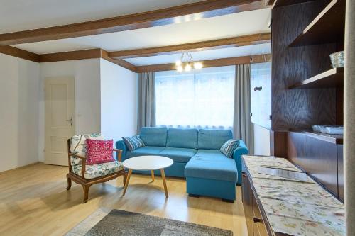 Una sala de estar con un sofá azul y una mesa. en Ferienwohnung Brigitte, en Bad Mitterndorf