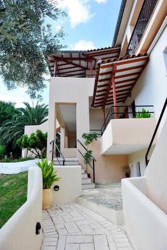 a house with white walls and stairs at Hotel Marina in Kolios