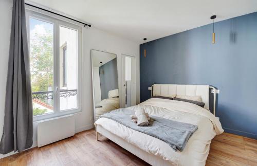 a bedroom with a bed with a blue wall at Charmant T2 Alfortville in Alfortville