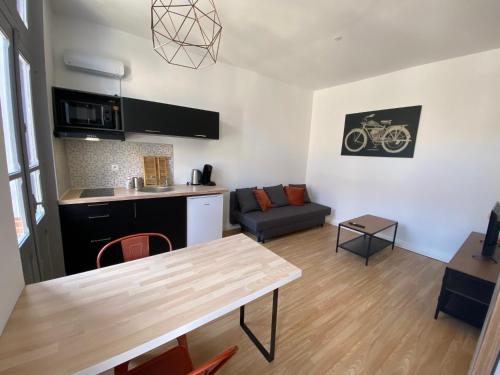 eine Küche und ein Wohnzimmer mit einem Tisch in der Unterkunft V3 Studio tout confort plein centre 5 min Golfech in Valence-dʼAgen