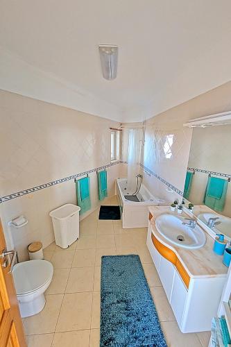 a bathroom with a sink and a toilet and a tub at Ericeira Sunset Apartment in Ericeira