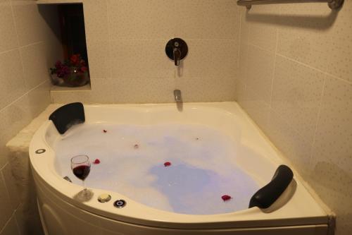uma banheira com um copo de vinho em Soothing 2-bedroom country house in Huayllabamba em Huayllabamba