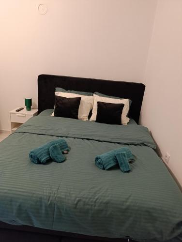 a bed with two pairs of towels on it at Studio San in Arandjelovac