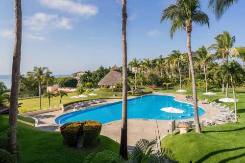 vista sulla piscina di un resort con palme di Faro de Mita Luxury Beach Condo a Punta Mita