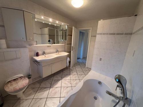 a bathroom with a tub and a sink and a toilet at 108 qm EG-Fewo mit Garten - Grill - Westterrassen in Oevenum